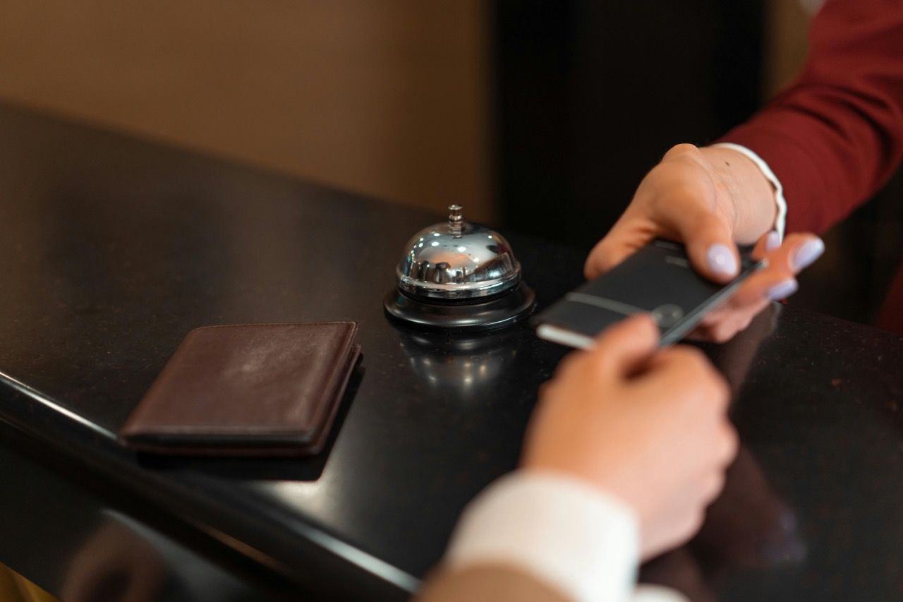 Receptionist handing over a room key card.