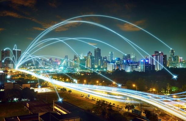 Time-lapse shot of a main street in a big city at night with stylized glowing arches.